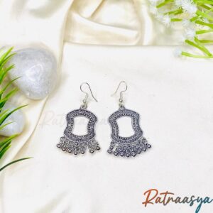 Moroccan window oxidized silver dangler earrings with ornate beaded accents on white background