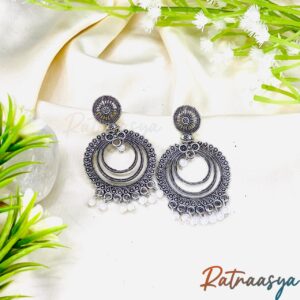 Pearl fringe circular oxidized silver earrings with concentric circle motifs and pearl drops on white background