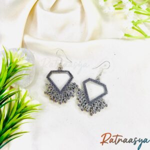 Hexagon oxidized silver dangler earrings with intricate detailing and bead accents on white background