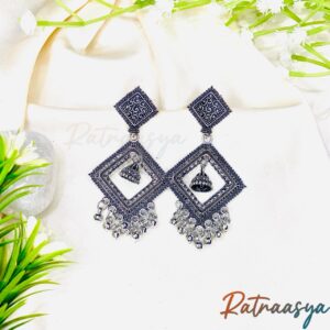 Geometric square oxidized jhumki earrings by Ratnaasya with dual square frames and dangling jhumki detailing on a cream fabric background
