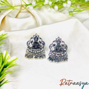 Lakshmi oxidized stud earrings by Ratnaasya featuring divine goddess motif and sparkling accents on a cream background