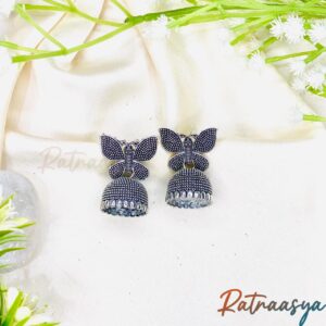 Butterfly motif oxidized jhumki earrings by Ratnaasya with detailed butterfly tops and oxidized dome drops on a cream background
