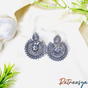 Antique oxidized silver chandbali earrings with leaf motifs and central shimmer accents on white background