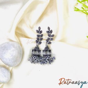 Leaf motif oxidized silver dome jhumka earrings with intricate design and hanging beads on white background