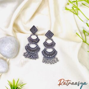Boho layered oxidized silver dangler earrings with geometric patterns and hanging beads on white background